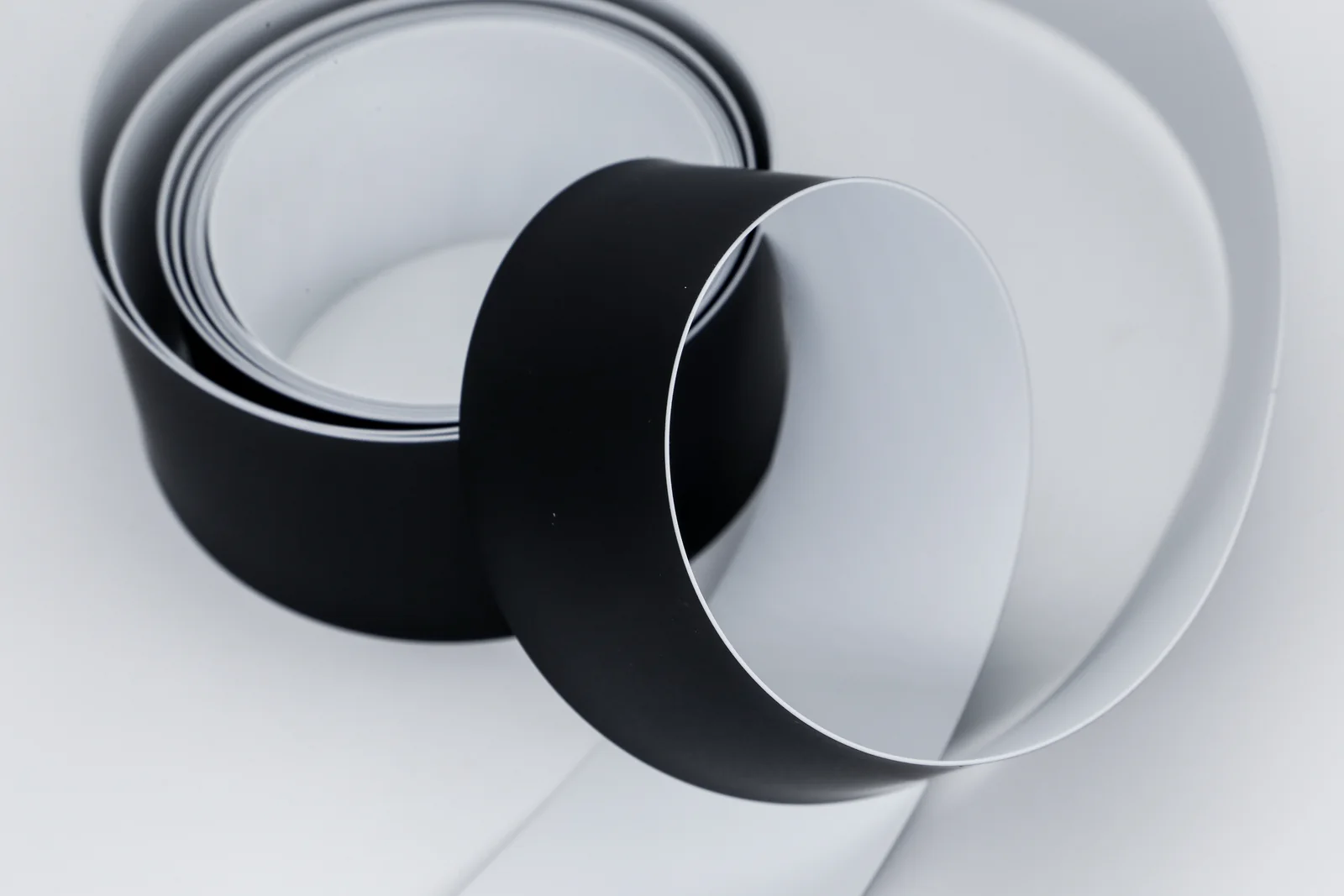 Black and white flat transmission belts arranged in loops
